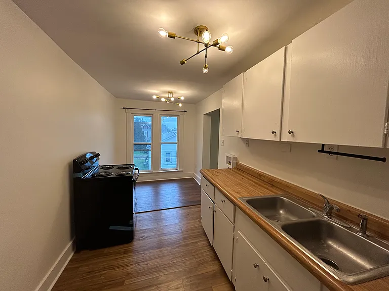 Kitchen with brand new stove, fridge, lighting, and new flooring in dining nook