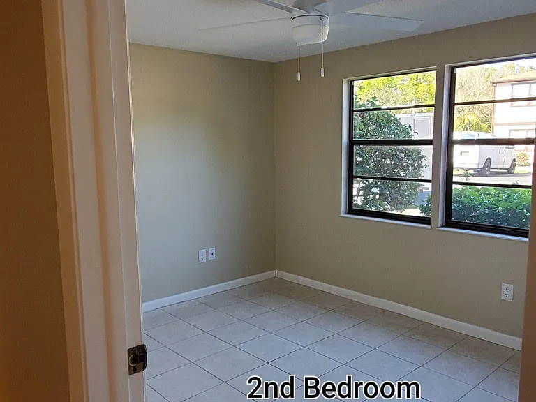 Spacious 2nd bedroom with double windows, new faux blinds and new ceiling fan.