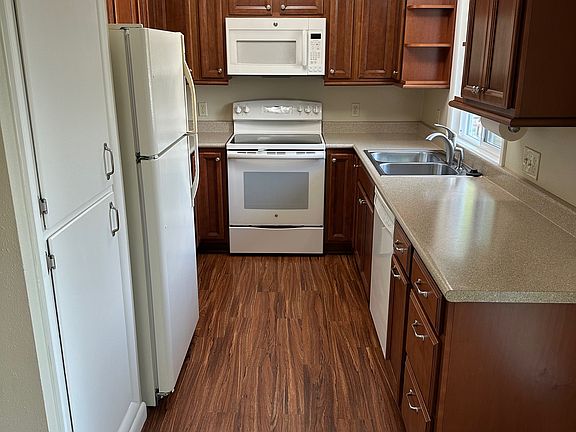 Kitchen with pantry, refrigerator, microwave, stove & dishwasher.