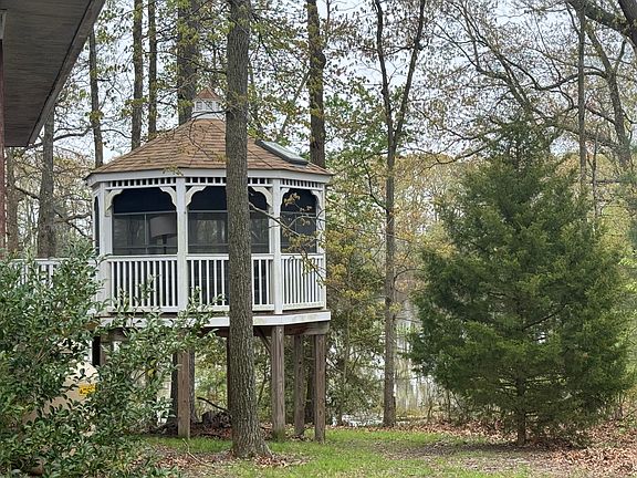 Screened in gazebo with skylight overlooking water. This also has vinyl windows and electric outlet.