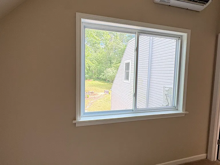 The primary bedroom overlooks the backyard, providing peaceful views for a relaxing retreat.