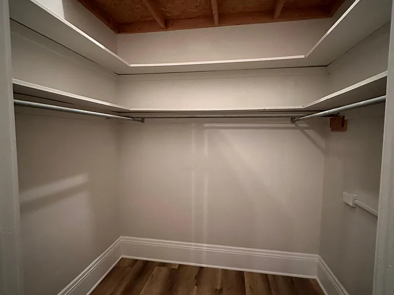 Walk-in closet in bedroom 1 with storage above