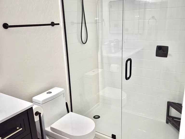 Hallway bathroom near the 2nd and 3rd bedrooms. Completely remodeled with upgraded walk-in shower, easy access to shower handler, eco-friendly toilet.