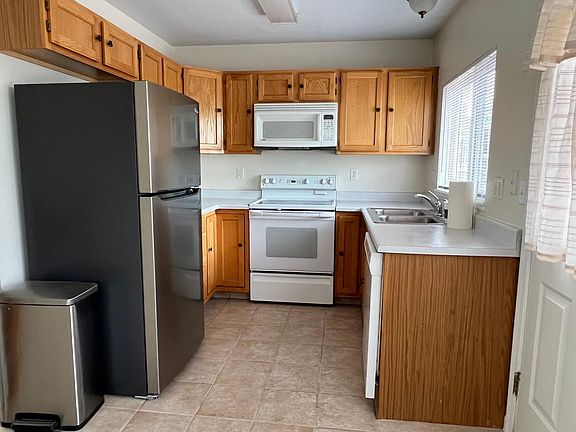 Kitchen with appliances: refrigerator, microwave, stove, disposal, and dishwasher.