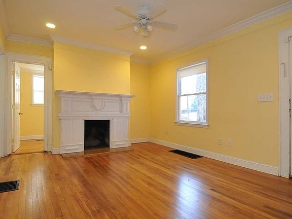 Living room with hardwood floors and adjacent sunroom.