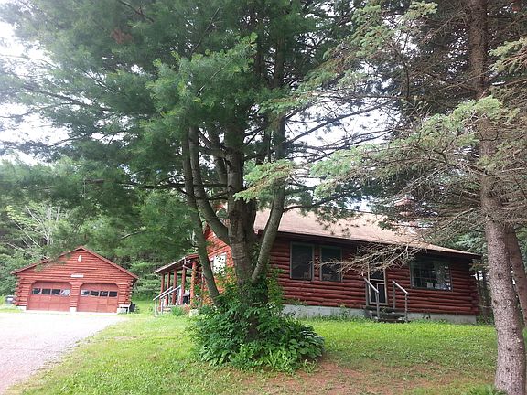 view of front of home from between evergreens on right side of driveway