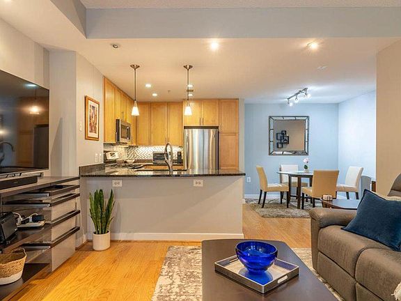 Living room opens to kitchen and dining room. Watch the 70_ wall-mounted TV from anywhere!