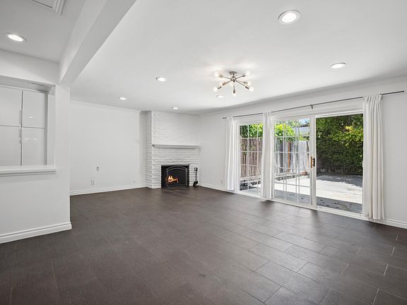 The living room has a fireplace and connects to the backyard through sliding glass doors