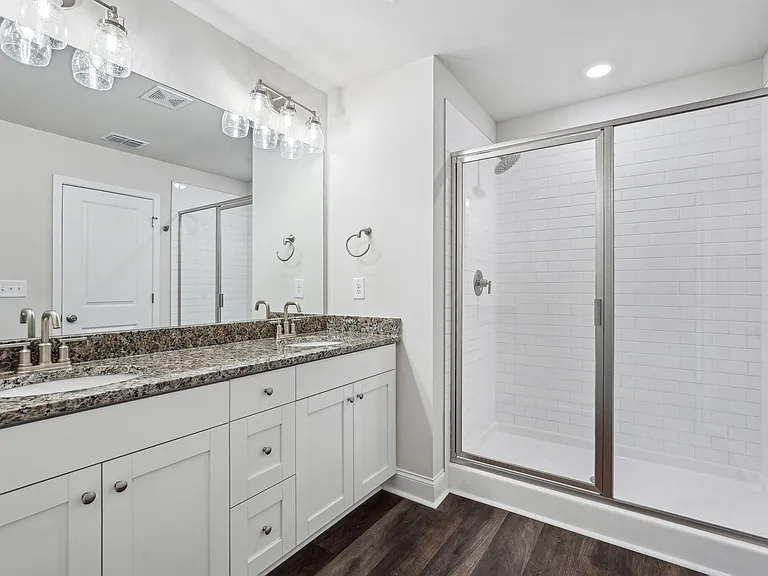 Primary bathroom with double vanity, walk-in shower and walk-in closet.