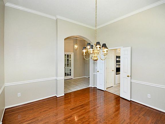 Beautiful formal dining with hardwood floors and beautiful light fixtures.