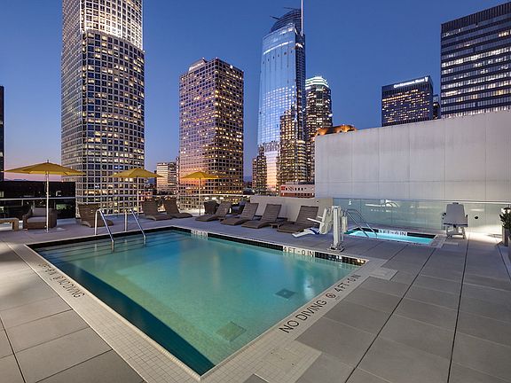 Rooftop swimming pool and spa surrounded by lounge seating.