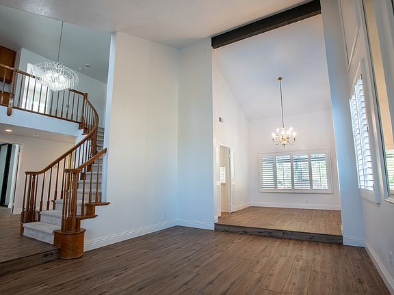 Living & Dining: Bright and open, the formal living and dining area boasts large windows with plantation shutters, perfect for entertaining or family gatherings in a spacious and sunlit setting.