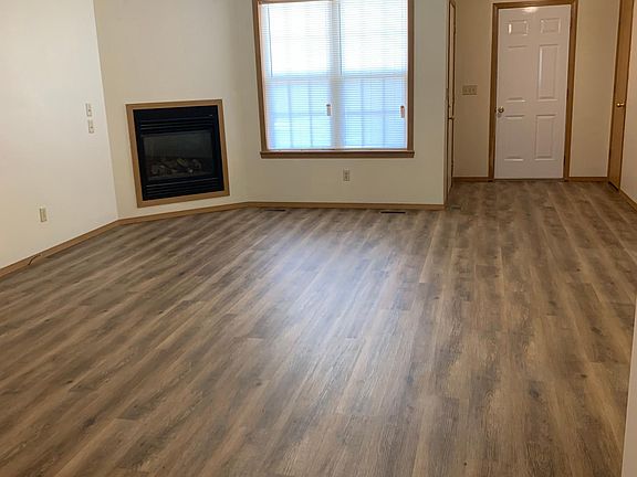 From Dining Room back towards Front entry door and Garage door. Fireplace shown on left. Matching entry light and ceiling fan.
