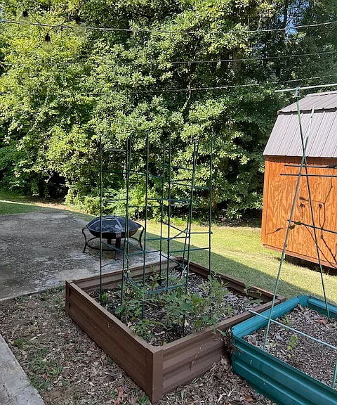 Small patio off Carport with firepit and raised flower/garden beds