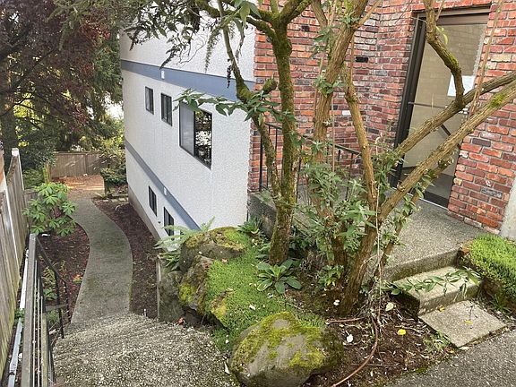 From front off-street parking stall. Building entrance to the right, exterior stairway to back courtyard and access to this ground floor unit #4.