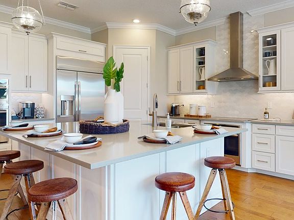 This elegant kitchen features designer-selected quartz countertops and cabinetry, superior stainless