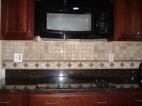 Glass Cooktop and Large Microwave with custom splash & Dark Cherry Cabinets