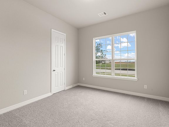 The third bedroom features plush carpet, neutral paint, large windows and a walk-in closet
