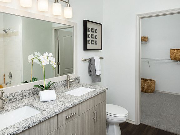 Remodeled bathrooms feature wood grain cabinets and framed mirrors