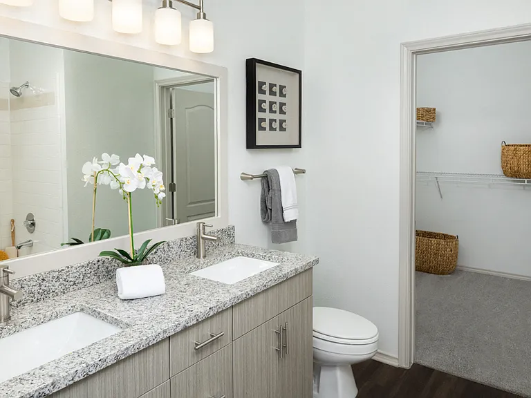 Remodeled bathrooms feature wood grain cabinets and framed mirrors