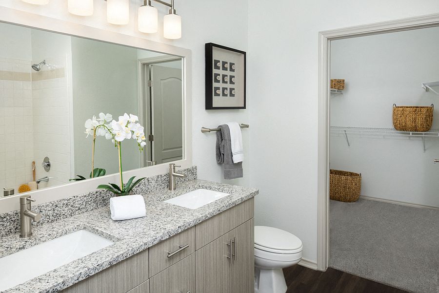 Remodeled bathrooms feature wood grain cabinets and framed mirrors