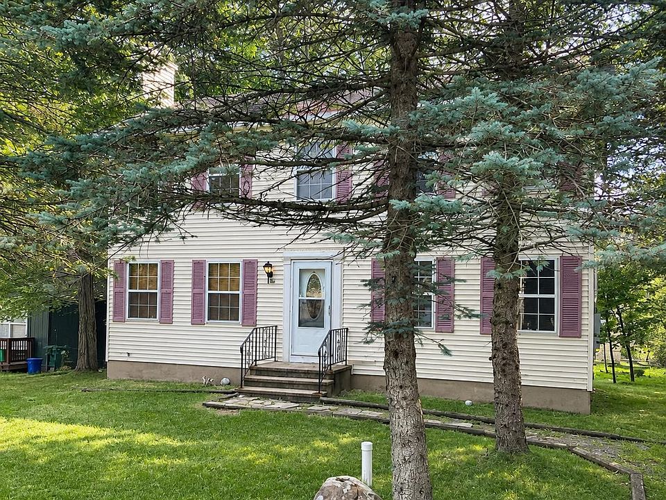 Spacious front lawn with beautiful shade trees and a welcoming entrance