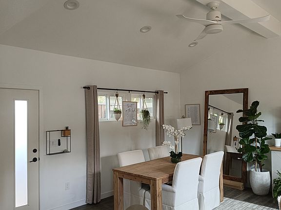 View of living room with dining table option and mirror covering door.