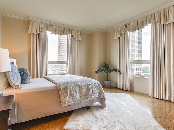 Spacious master bedroom with crown molding and large windows