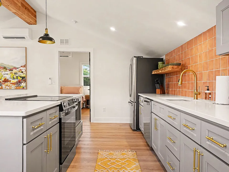 Kitchen with all new appliances, bar stool seating for 3, and a work station with chair