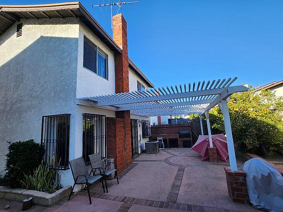 Backyard with patio cover, built in sink & gas powered bbq grill with concrete flooring