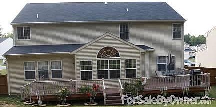 Back of house with deck
						:
						Composite Deck with Vinyl Railing and rose bushes around deck