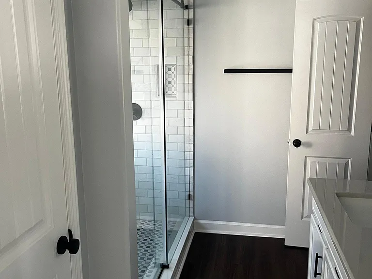 Primary bathroom with glass shower enclosure, and ample vanity storage.