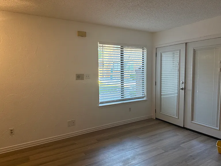 Living area with French doors with enclosed blinds.