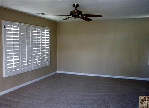 Living Room with Planation Shutters, Freshly Painted and New Carpet!  Great Views of the Golf Course from your Living Room!