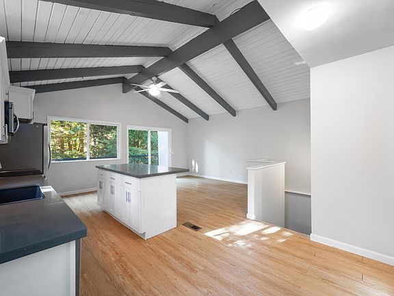Updated bright & open concept kitchen with quartz counter tops, stainless appliances & vaulted ceilings. Sliding glass doors to private back patio.