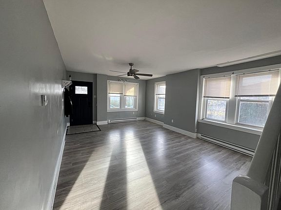Spacious living room w/ coat rack and tons of lighting.