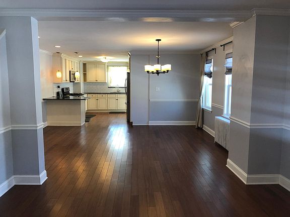 View towards rear of house from main living room towards dining room and kitchen. Rear entrance with mudroom, laundry and powder room through kitchen to the right.