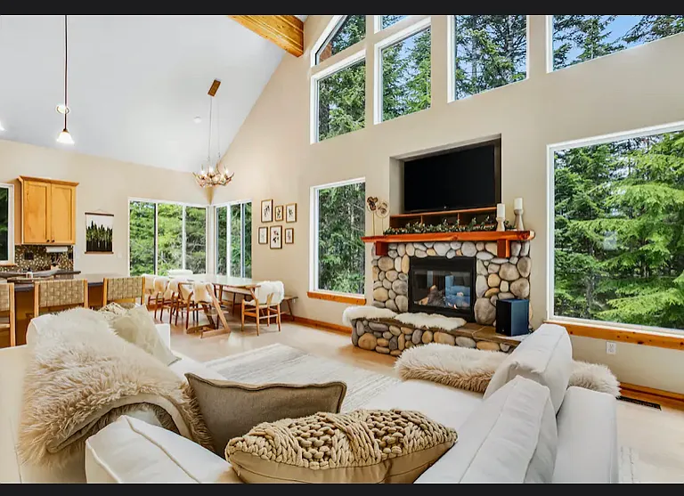 large living room with 26' ceilings and beautiful views of the trees
