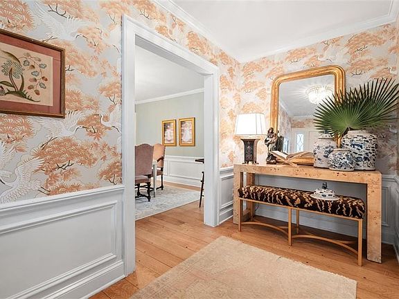 Corridor with crown molding and wood-type flooring