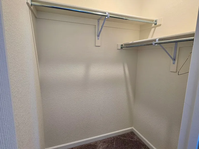 Large walk-in closet of second bedroom.