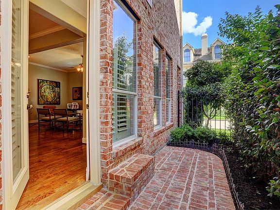 Inside a gated community, the front entrance to this beautiful corner home is surrounded by lush lan