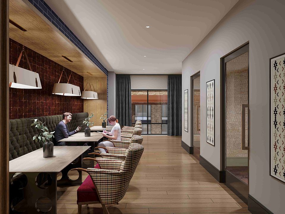 A flexible business lounge offering collaborative seating, vibrant artwork, and a polished environment for work or study.