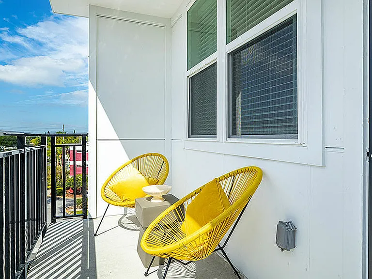 Enjoy your morning coffee on this vibrant balcony, a perfect spot for sunshine and relaxation.