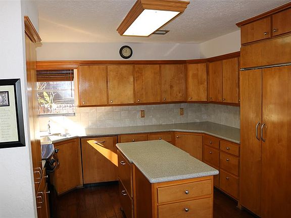 Kitchen with numerous cabinets and built in fridge. Nice hardwood floors.