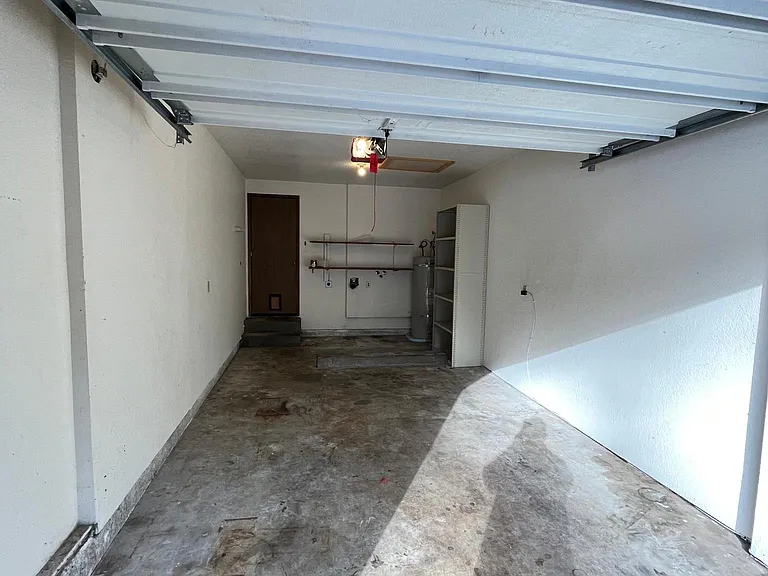 Garage with Storage Shelves, Garage Door Opener, and Washer-Dryer Hookup