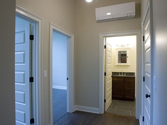 Hall from front door to bathroom, walk in closet on right, and two bedrooms on left