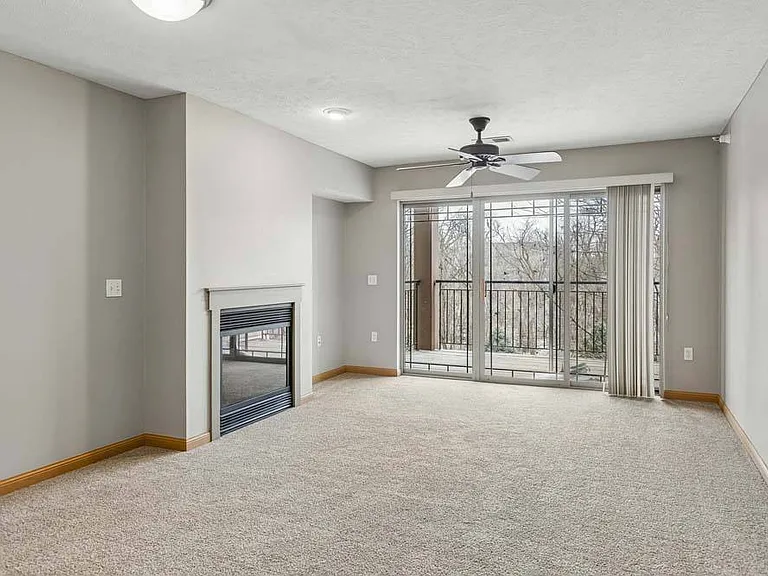 Expansive windows, a cozy fireplace, and a private balcony create a bright living space made for relaxing year round.