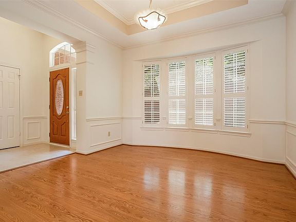 Open concept living in this formal dining room with bay windows and planation shutters, as it open to the den and kitchen.