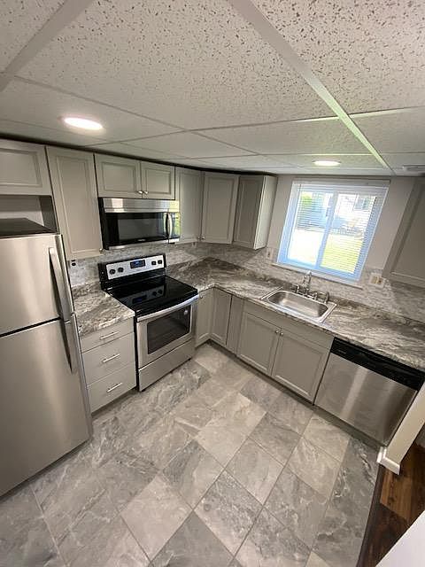 Kitchen looking at rear yard through window. Rear door of town home has access to newly poured patio and nice yard behind home.