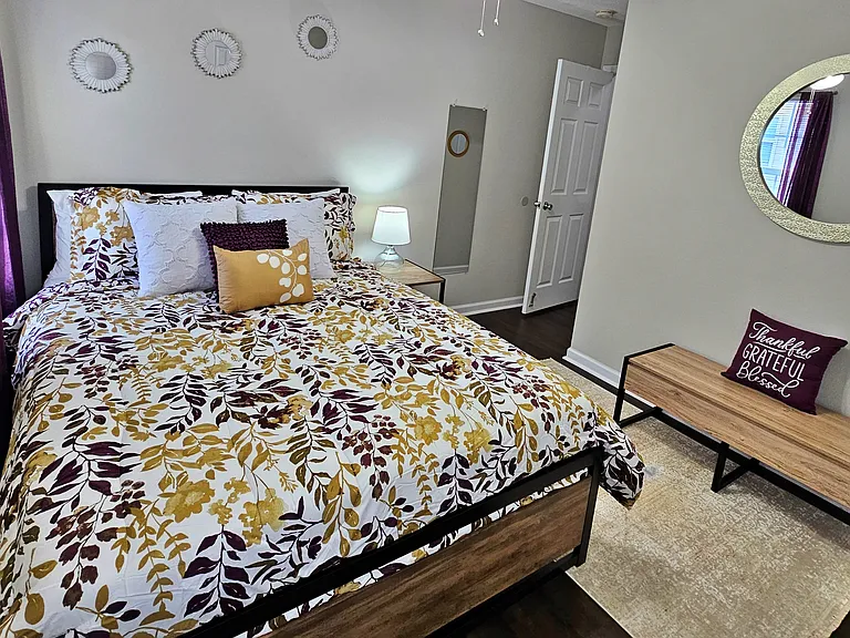 Enjoy this simple but unique queen guest bedroom. There is a bench that also serves as storage. The room also has a full-length mirror.